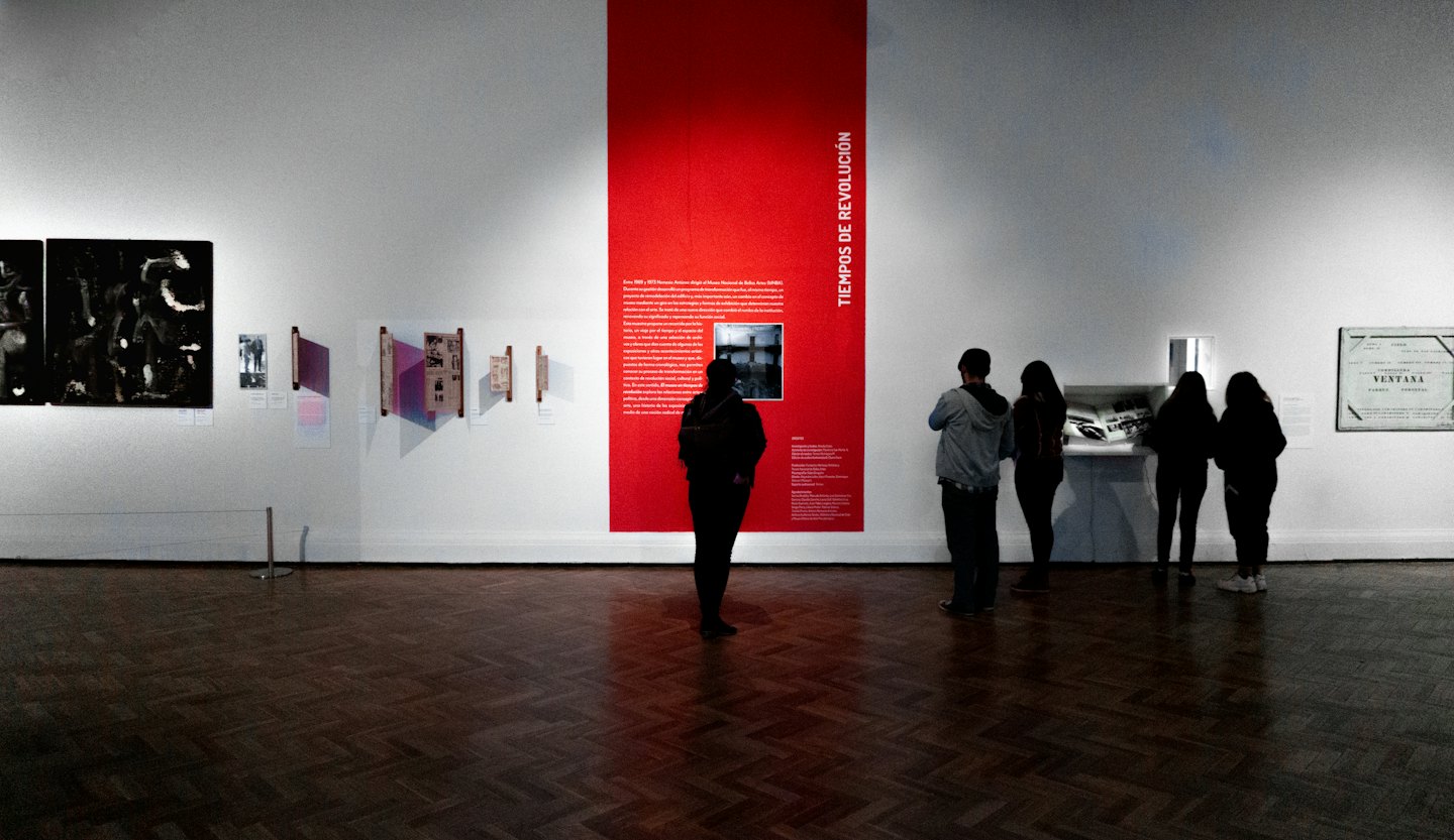 Ludzie oglądający sztukę w nowoczesnej przestrzeni galerii.